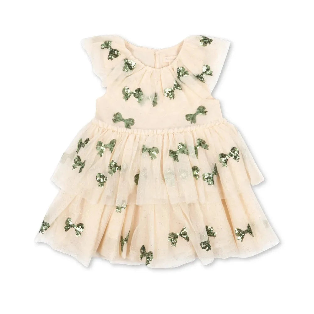 A baby girl's tiered tulle dress in a light cream color, decorated with small green embroidered bows and floral motifs, shown against a plain white background.